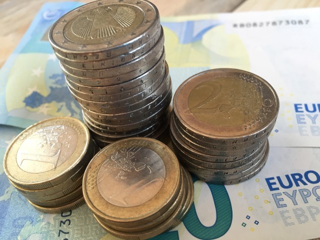 Geldscheine und gestapelte Euromünzen