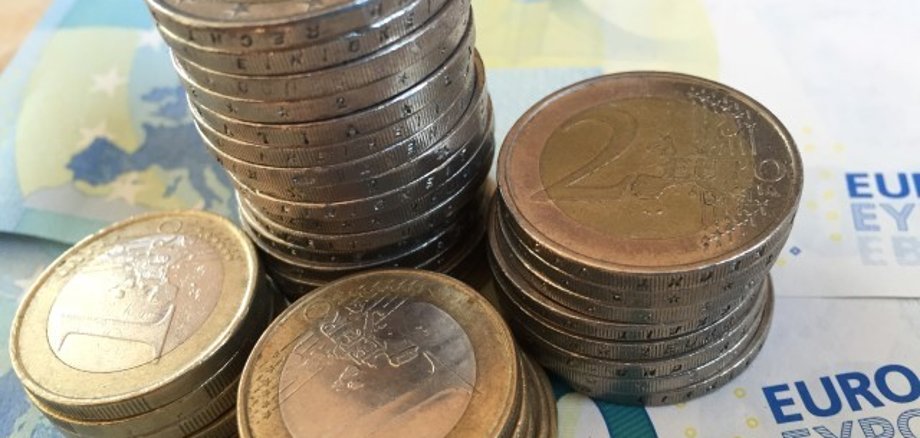 Geldscheine und gestapelte Euromünzen